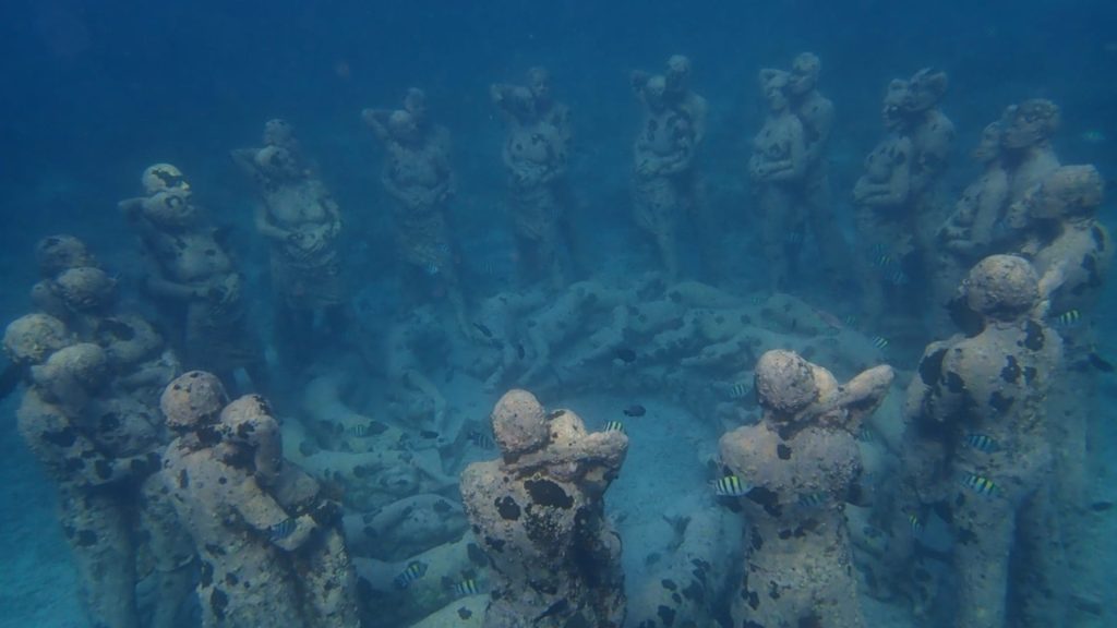 MUSA Underwater Sculpture Reef in Cancún Marine life swimming around sculptures at the MUSA Underwater Museum in Cancún