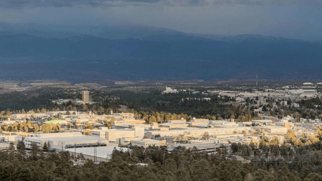 Aerial view of Los Alamos National Laboratory, where physicists conducted the quantum arrow of time reversed study, set against a mountain landscape
