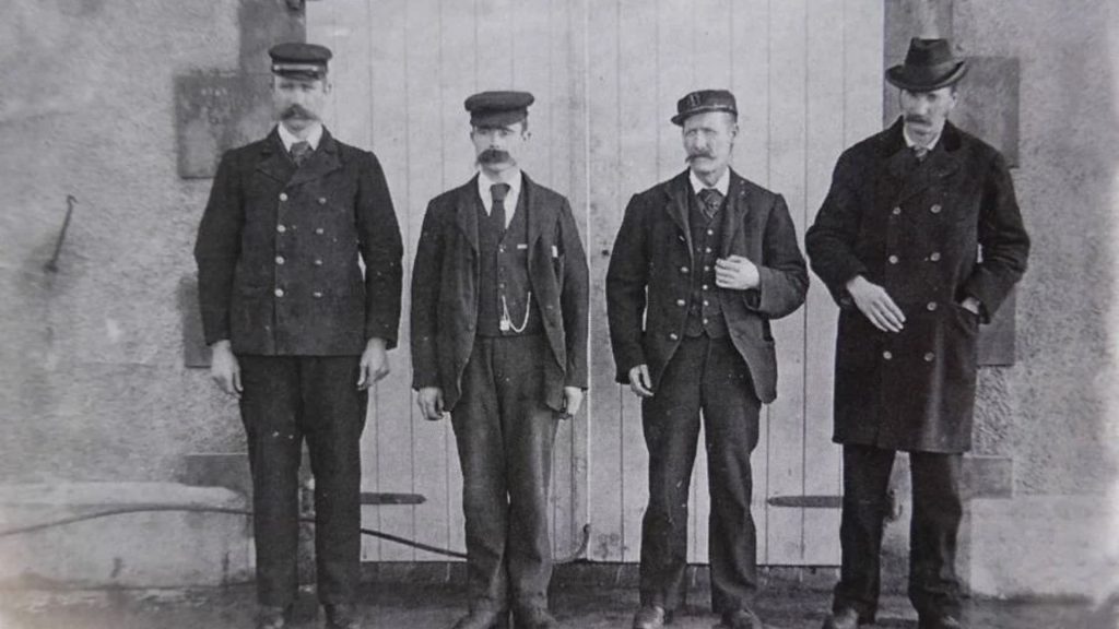 James Ducat, Thomas Marshall, Donald McArthur and Superintendent Robert Muirhead standing outside a building, circa 1900.