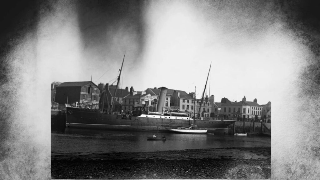 Black-and-white photograph of lighthouse tender Hesperus moored alongside East Quay at Ramsey Harbour.